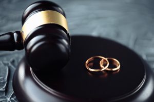 Picture of two wedding rings sitting next to a gavel.