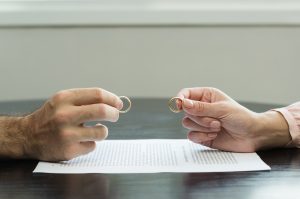 Picture of a divorcing couple exchanging their wedding rings.