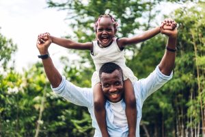 Picture of a father giving his daughter a piggyback ride.