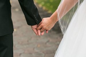 Picture of a bride and groom holding hands.