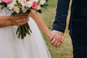 Picture of a bride and groom holding hands.