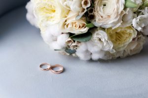 Picture of a bridal bouquet and a pair of gold wedding rings.